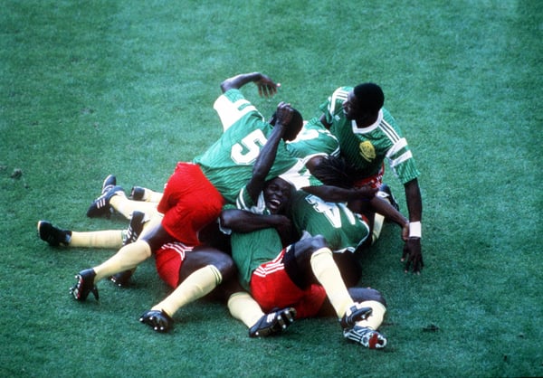 1990 年世界杯决赛，意大利米兰，1990 年 6 月 8 日，阿根廷 0 比 1 战胜喀麦隆，喀麦隆球员们叠在一起庆祝奥马姆·比伊克打入的唯一进球（图片由 Bob Thomas Sports Photography 通过 Getty Images 提供）。