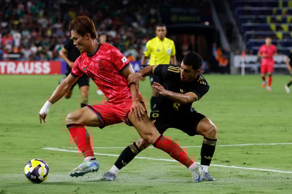 在韩国与墨西哥的国际友谊赛中，韩国前锋吴亨宇（19号）在墨西哥中场球员埃里克·利拉（6号）面前发起进攻。