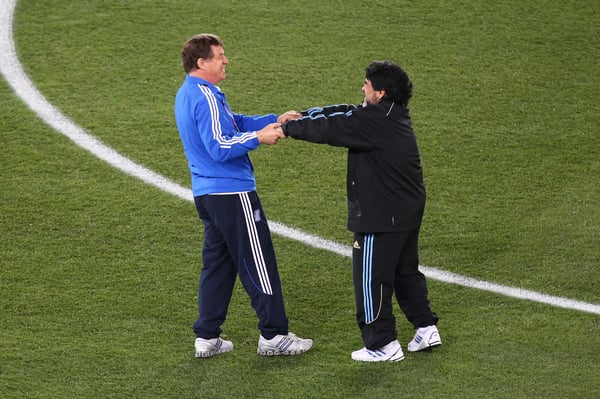 世界杯FIFA体育新闻：在2010年国际足联世界杯希腊对阵阿根廷的比赛前，奥托·雷哈格尔和迭戈·马拉多纳互相问候。