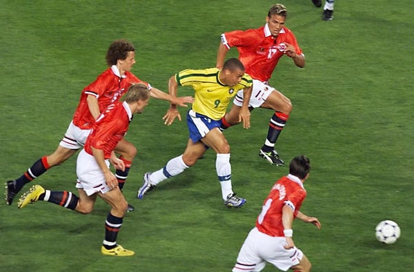 世界杯FIFA体育新闻:在1998年法国世界杯A组比赛中,巴西球员罗纳尔多在马赛韦洛德罗姆球场摆脱了几名挪威球员的防守。