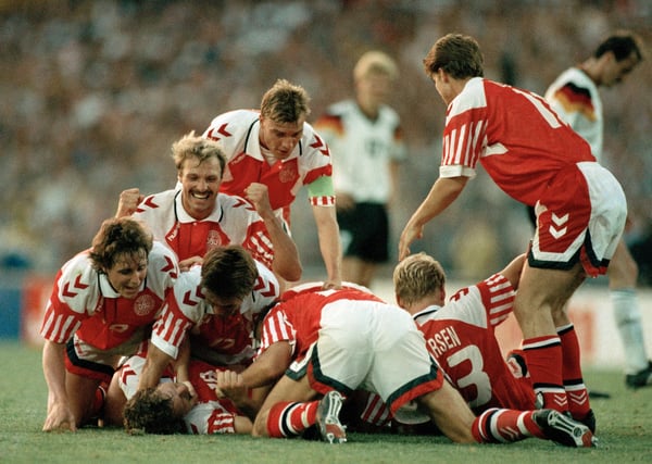 世界杯FIFA体育新闻:瑞典哥德堡 - 1992年6月26日:在1992年欧洲杯决赛丹麦对阵德国的比赛中,丹麦队在瑞典哥德堡新乌勒维体育场庆祝胜利。(图片由Professional Sport/Popperfoto via Getty Images/Getty Images提供)