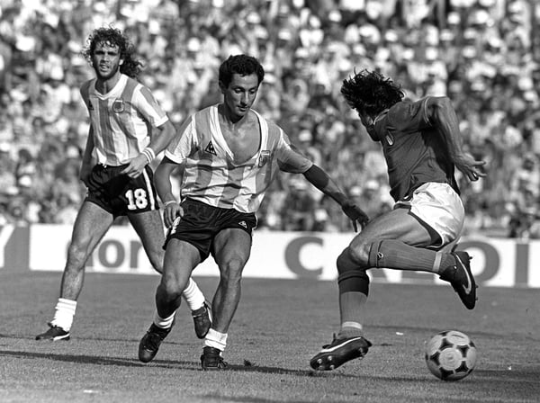 世界杯FIFA体育新闻：1982年西班牙世界杯C组比赛中，意大利球员布鲁诺·孔蒂在巴塞罗那萨里亚球场骗过阿根廷球员奥斯瓦尔多·阿迪列斯。