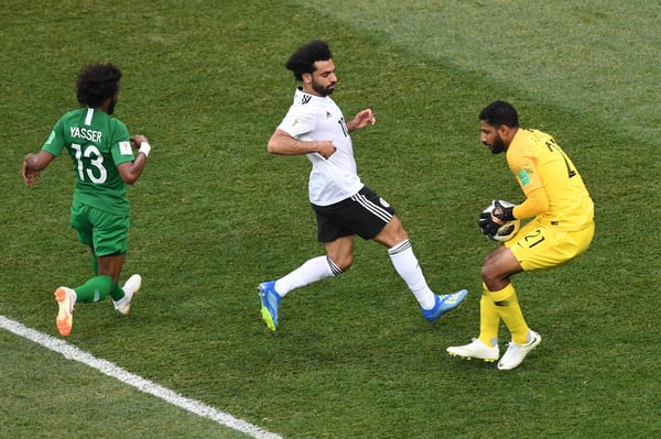 世界杯FIFA体育新闻：在2018年国际足联世界杯A组比赛中，沙特阿拉伯门将亚瑟·阿尔莫萨莱姆在埃及球员穆罕默德·萨拉赫的逼抢下将球抱住。比赛地点：沃尔沃格勒。