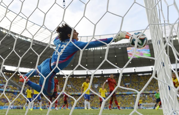 世界杯FIFA体育新闻：吉列尔莫·奥乔亚的传奇始于2014年对阵东道主巴西的零封。/ Yuri Cortez/AFP/Getty Images