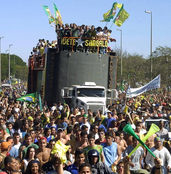 世界杯FIFA体育新闻:巴西队在2002年韩日世界杯夺冠后,乘坐一辆由阿塞舞巨星伊薇特·桑加洛(Ivete Sangalo)演奏的音乐花车,穿过巴西利亚的街道。