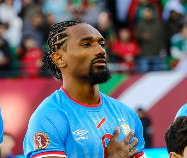 世界杯FIFA体育新闻：摩洛哥拉巴特 - 1月8日：2026年1月6日，在穆莱·哈桑体育场举行的2025年非洲杯16强赛对阵阿尔及利亚的比赛前，刚果民主共和国球员萨缪尔·穆图萨米在奏国歌时，手抚胸口，展现爱国情怀。这位边锋专注的神情反映了这场淘汰赛对“豹队”（刚果民主共和国队昵称）的重要性。