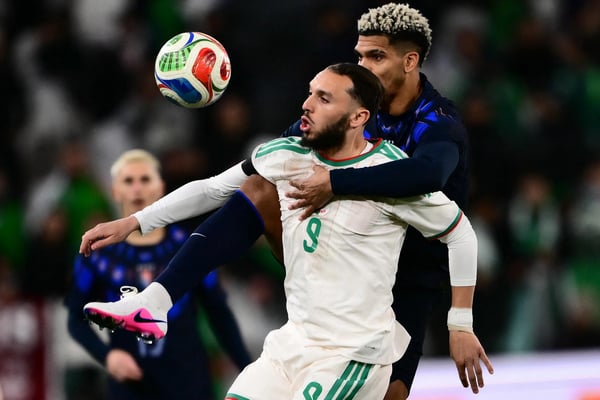 世界杯FIFA体育新闻：阿尔及利亚球员阿明·古伊里护球，乌拉圭球员罗纳德·阿劳霍试图抢球。