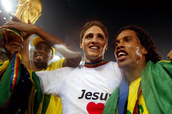 世界杯FIFA体育新闻：在2002年韩日世界杯决赛中，巴西队在横滨国际体育场以2比0战胜德国队后，埃德米尔森和罗纳尔迪尼奥与国际足联世界杯奖杯合影庆祝。
