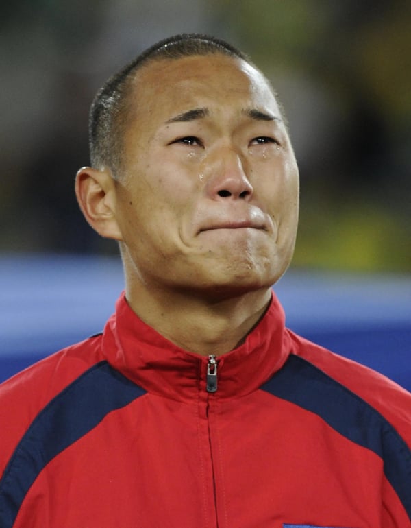 世界杯FIFA体育新闻：在2010年南非世界杯G组小组赛约翰内斯堡埃利斯公园体育场，朝鲜国家队与巴西队比赛前，在奏朝鲜国歌时，金钟泰世泪流满面。