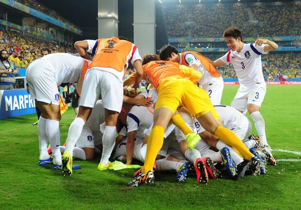 世界杯FIFA体育新闻：在2014年巴西世界杯H组比赛中，韩国队球员在库亚巴潘塔纳尔体育场庆祝李根镐攻破俄罗斯队球门。