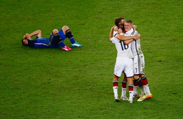 世界杯FIFA体育新闻：在2014年里约热内卢世界杯决赛中，德国队在加时赛中以1-0战胜阿根廷队，塞尔吉奥·阿圭罗悲痛欲绝地躺在马拉卡纳球场的草坪上，而菲利普·拉姆、托马斯·穆勒和巴斯蒂安·施魏因施泰格则在庆祝胜利。