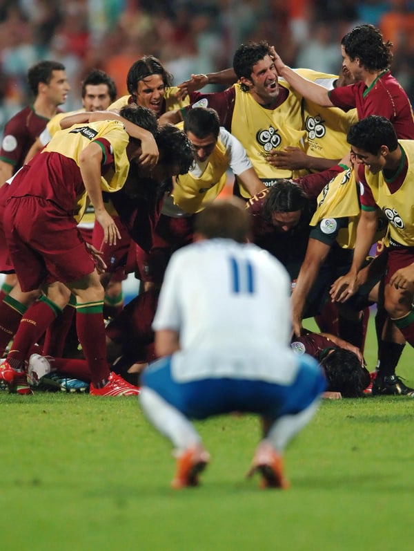 世界杯FIFA体育新闻：在2006年德国世界杯16强赛中，葡萄牙队在纽伦堡战胜荷兰队后，阿尔扬·罗本沮丧地蹲在地上庆祝胜利。