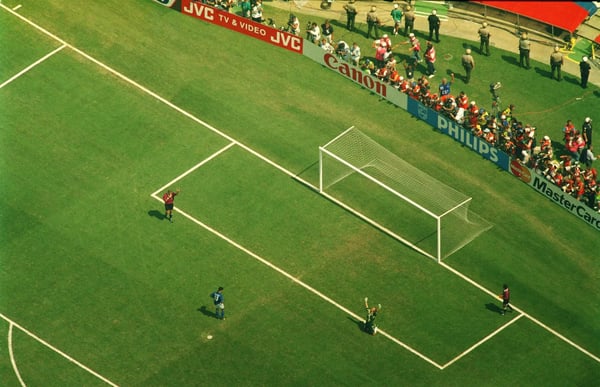 世界杯FIFA体育新闻：意大利球员罗伯特·巴乔低下了头，而巴西球员塔法雷尔则在庆祝进球。
