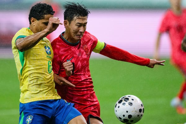 世界杯FIFA体育新闻:韩国球员孙兴慜(右)和巴西球员道格拉斯·桑托斯追逐球