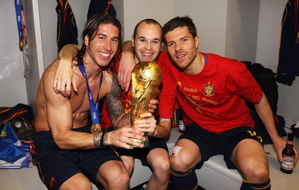 世界杯FIFA体育新闻:塞尔吉奥·拉莫斯、安德烈斯·伊涅斯塔和哈维·阿隆索在西班牙赢得2010年南非世界杯后举起奖杯庆祝。