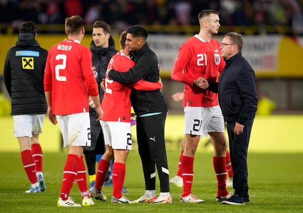 世界杯FIFA体育新闻：在与德国队的友谊赛后，拉尔夫·朗尼克（右）和他的助手们拥抱了他们的球员。