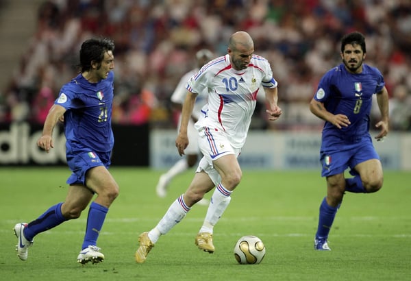世界杯FIFA体育新闻:在2006年德国世界杯决赛中,法国球员齐达内在柏林奥林匹克体育场控球,意大利双星安德烈亚·皮尔洛和詹纳罗·加图索之间争抢球权。