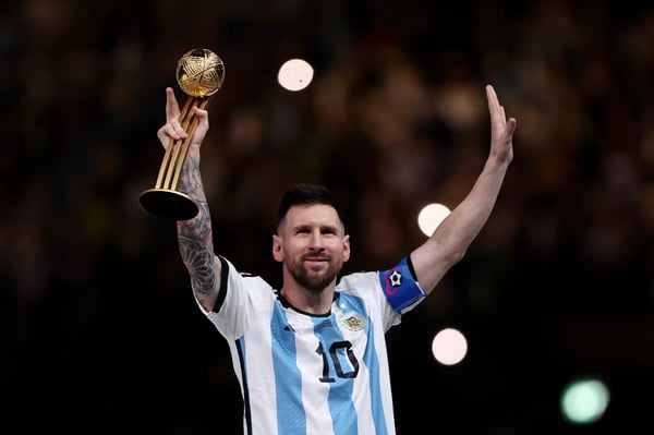 世界杯FIFA体育新闻:阿根廷球星莱昂内尔·梅西在2022年卡塔尔世界杯决赛战胜法国队后,手捧阿迪达斯金球奖杯合影。