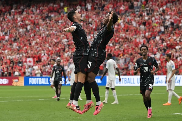 世界杯FIFA体育新闻：在温哥华体育场举行的世界杯加拿大对阵卡塔尔的比赛中，加拿大球员乔纳森·戴维与队友斯蒂芬·尤斯塔奎奥庆祝球队以3-0领先。