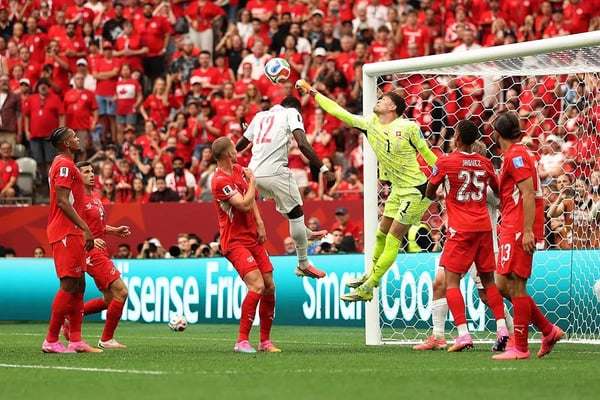 世界杯FIFA体育新闻：2026年国际足联世界杯期间，瑞士队1号球员格雷戈尔·科贝尔在加拿大队12号球员塔尼·奥卢瓦塞伊面前击球。