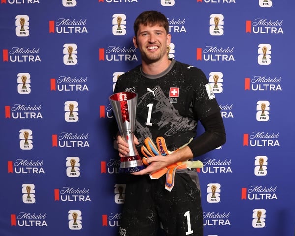 世界杯FIFA体育新闻:在2026年国际足联世界杯16强赛瑞士对阵哥伦比亚的比赛中,瑞士球员格雷戈尔·科贝尔手捧米凯罗超醇啤酒最佳球员奖杯合影。