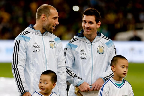 世界杯FIFA体育新闻:2014 年 10 月 11 日,在中国北京鸟巢体育场举行的 2014 年美洲超级德比阿根廷对阵巴西的比赛前,阿根廷队的莱昂内尔·梅西和巴勃罗·萨巴莱塔列队。