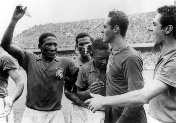 世界杯FIFA体育新闻:1958年瑞典世界杯决赛获胜后,哭泣的贝利被他的巴西队友们安慰。