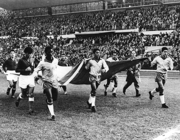 世界杯FIFA体育新闻：1962年国际足联世界杯半决赛，巴西队以4比2战胜智利队后，球员们在圣地亚哥国家体育场内挥舞着智利国旗游行。